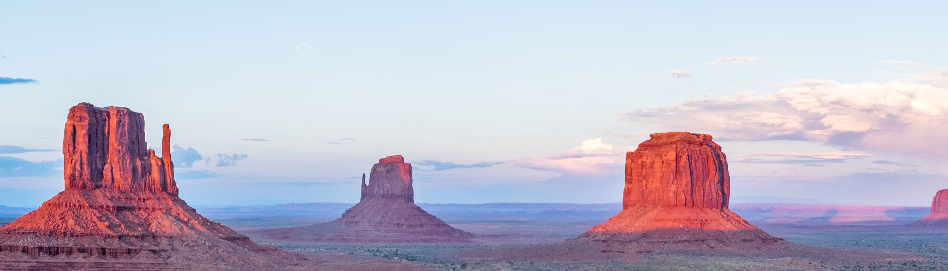 Sunset of a clear sky over a desert with large red rock formations